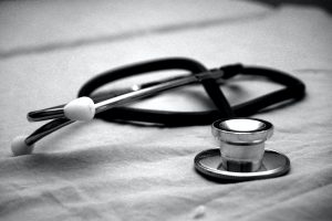 A stethoscope sitting on a sheet in black and white