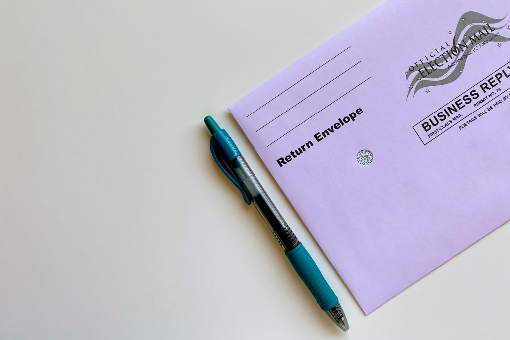 An absentee ballot envelope and a pen
