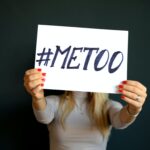 Woman holds a sign that reads #METOO